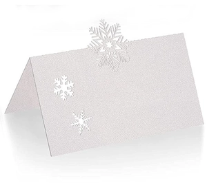 Detailed view of white glitter snowflake place cards with elegant laser-cut details