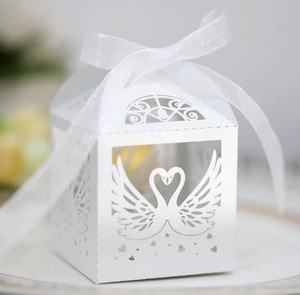 Detailed laser-cut white swan wedding candy box with elegant organza ribbon bow