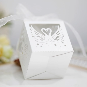Detailed view of white hollow swan wedding candy box with elegant ribbon and heart cutouts