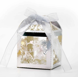 Macro shot of laser-cut silver wedding candy box with heart, rose and Love text