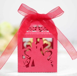 Macro view of red laser-cut wedding gift box with bride and groom silhouette detail
