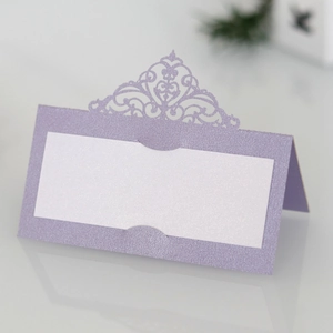 Detail of laser-cut lavender shimmer paper table card with intricate hollow lace pattern