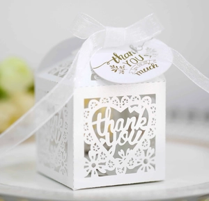 White laser-cut heart favor box with ribbon and gold thank you gift tag for weddings