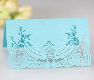 Light blue pearlescent lace place card with intricate laser-cut floral details