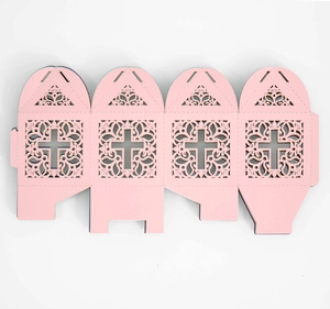 Macro view of laser-cut paper gift box featuring ornate European cross and floral patterns