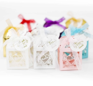 Detailed laser-cut heart candy boxes in multiple colors with ribbons and thank you tags