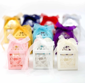 Close-up of hollow laser-cut heart candy boxes with rose patterns and Love lettering