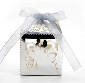 Detail of silver laser-cut wedding favor box with groom and bride silhouette and ribbon