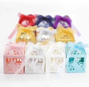 Laser-cut wedding favor boxes with groom and bride silhouettes and organza ribbons