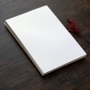Macro shot of blank white pearl paper wedding invitation cards on a dark wood table