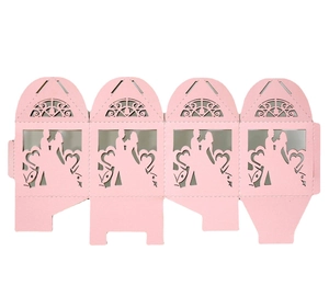 Flat lay of laser-cut pink wedding favor box with heart silhouettes and ribbon details