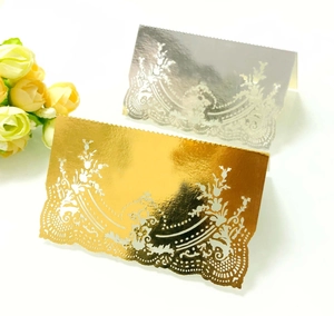 Close-up of laser-cut lace place cards in gold and silver metallic pearl paper