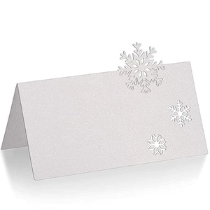 White glitter laser-cut snowflake place cards for elegant Christmas wedding table settings