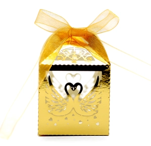 Elegant gold laser-cut swan candy box with yellow organza ribbon for weddings