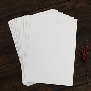 Elegant white pearlescent paper wedding invitation cards with dried flowers on wood