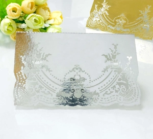 Detailed laser-cut lace pattern on silver mirror-finish wedding place cards for tables