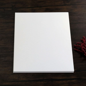 Close-up of premium blank white pearlescent paper cards stacked on a wooden surface