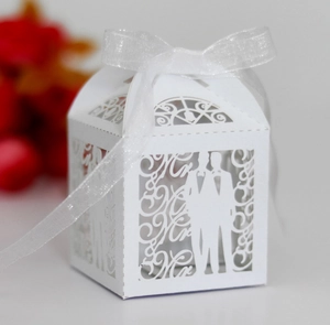 Macro detail of laser cut Mr & Mr white paper candy box with ribbon for weddings