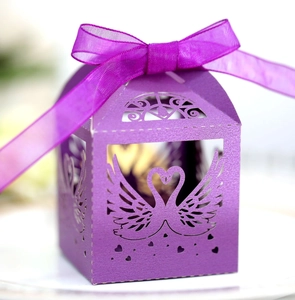 Detail of purple laser-cut swan heart candy box with elegant organza ribbon bow