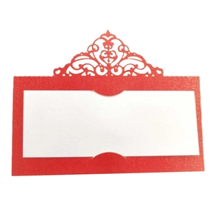 Detail of red laser-cut wedding place card with intricate geometric hollow patterns