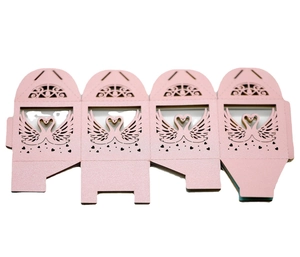 Detail of pink laser-cut wedding favor boxes with swan heart pattern and flat-lay design