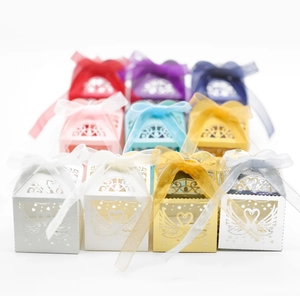 Detailed laser-cut hollow swan favor boxes with ribbon bows in multiple colors