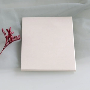 Close-up of premium cream white pearlescent paper cards with red dried flower decoration