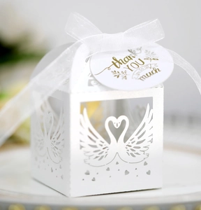 Detailed laser-cut white wedding favor box with swan heart motif and thank you ribbon