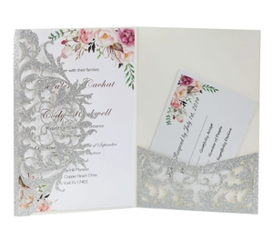 Detail of silver glitter laser-cut floral invitation cover with rose patterned insert card