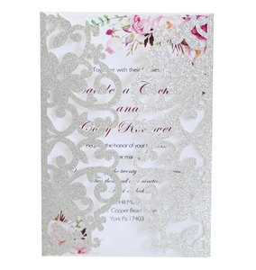 Dettaglio dell'invito di nozze traforato glitter argento con inserto floreale
