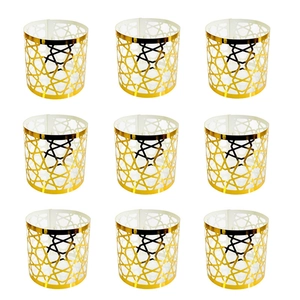 Set of nine laser-cut gold napkin rings featuring intricate geometric star patterns