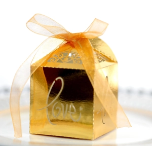 Macro view of golden cutout candy box with Love script and orange organza ribbon