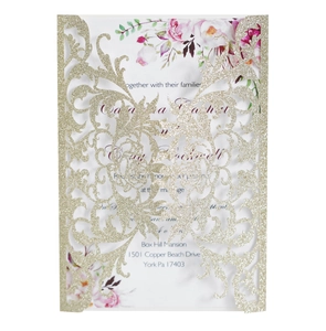Close-up of laser-cut gold glitter wedding invitation with elegant floral insert