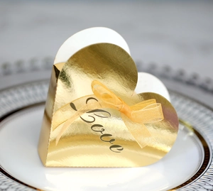 Close-up of a heart-shaped gold gift box with Love text and a yellow ribbon bow