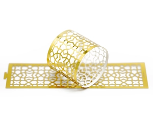 Detailed view of golden laser-cut napkin rings with elegant hollow geometric patterns