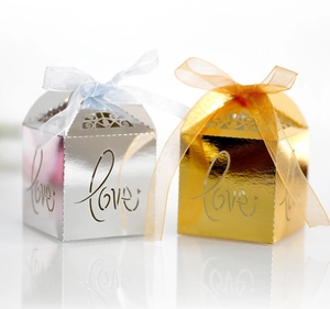 Detailed view of hollow Love candy boxes in metallic gold and silver with ribbon bows