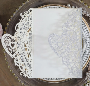 Intricate laser-cut floral heart wedding invitation cover with silver glitter finish