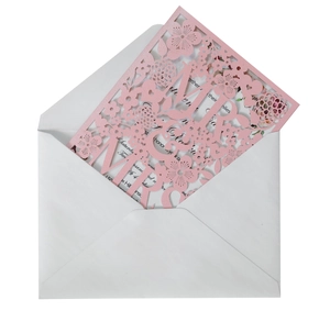 Detail of pink laser-cut MR & MRS wedding invitation with floral patterns and envelope