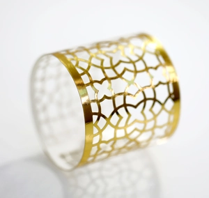 Macro view of golden hollow napkin ring with geometric floral pattern design