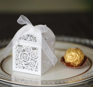 Close-up of laser cut rose pattern on white gift box with elegant organza ribbon