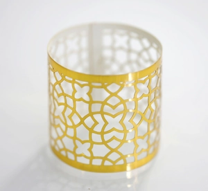 Detailed macro view of gold hollow-out cylindrical napkin ring with floral cutouts