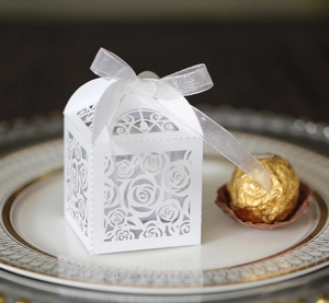 Detailed laser-cut rose pattern on a white gift box with elegant silk ribbon bow