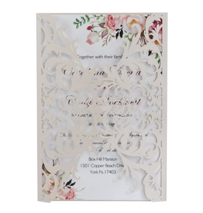 Intricate laser-cut floral pattern detail on cream white wedding invitation cover