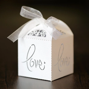 Detailed macro view of white laser-cut Love gift box with translucent silver ribbon bow