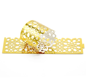 Detailed laser-cut gold paper napkin ring with floral lace pattern for weddings