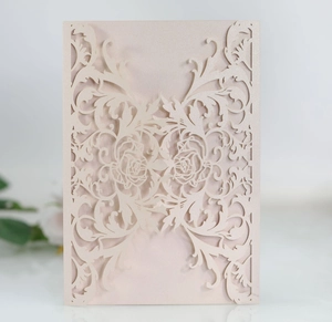 Detail of laser-cut rose floral pattern on champagne pearl paper wedding invitation
