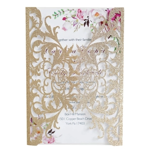 Detail of laser-cut gold glitter wedding invitation with floral inner card inserts