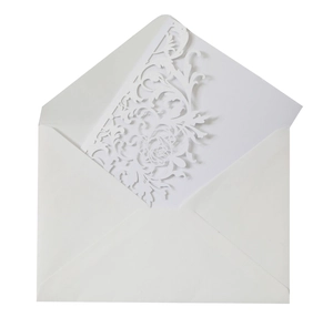 Detail of laser-cut floral pattern on white bridal shower invitation with white envelope