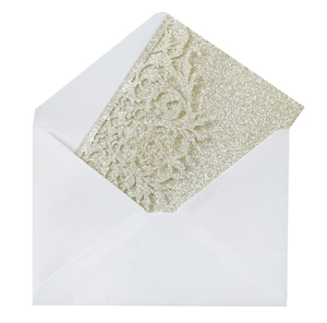 Detail of champagne gold glitter wedding invitation with laser cut floral pattern and white envelope