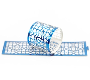 Detail of blue laser-cut paper napkin rings featuring hollow geometric flower patterns